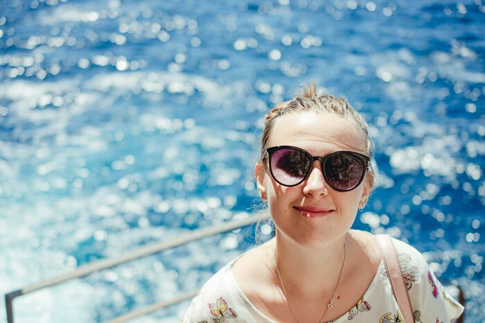 A woman in sunglasses on a boat, the ocean behind her, reflecting on the rarest things that have happened to her.