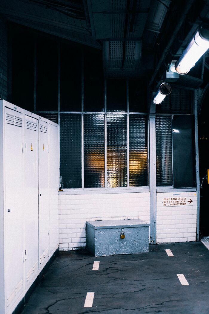A dark, abandoned-looking office space with lockers and a grimy window, hinting at an unusual final day at work story.