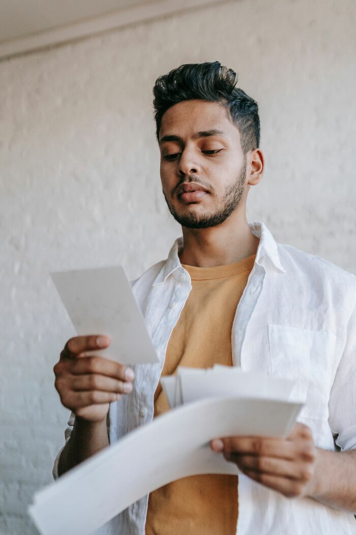 A man reads documents, experiencing unexpected twists and turns that changed his life.