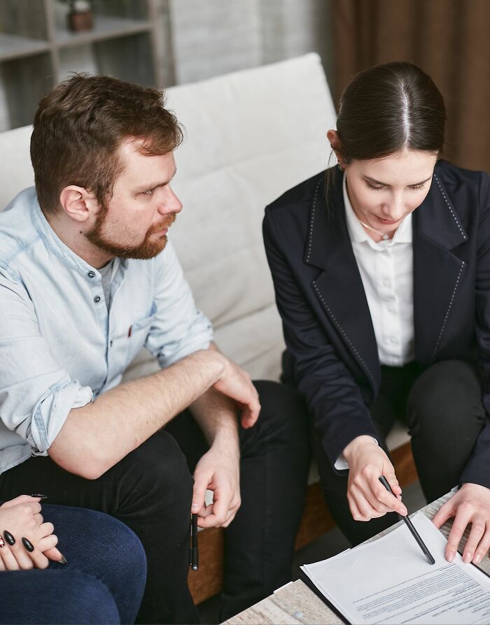 Two people discussing documents, representing the industry secrets involved in professional jobs.