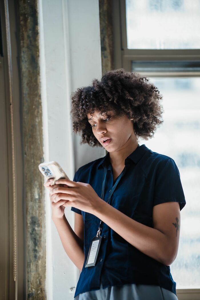 A woman looking suspiciously at her phone, revealing small cheating red flags.