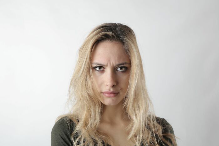 A blonde woman with a scowl, looking annoyed, represents entitled friends.