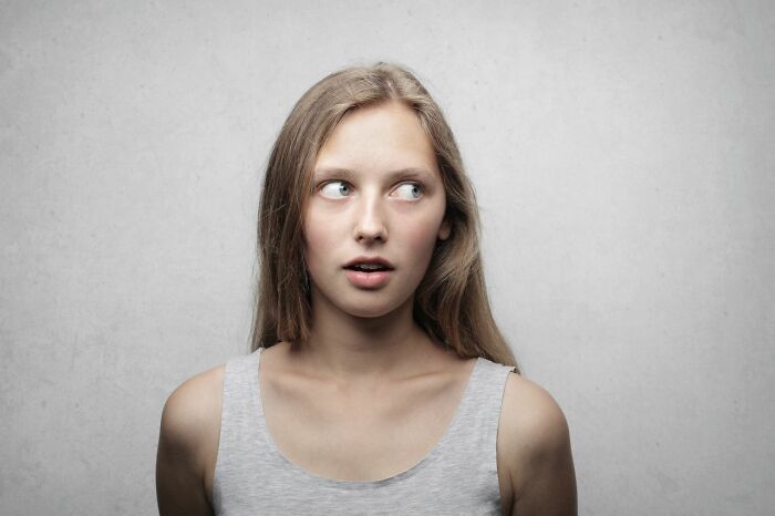A young woman with an amused, slightly shocked expression, representing stereotypically white phrases that crack people up.