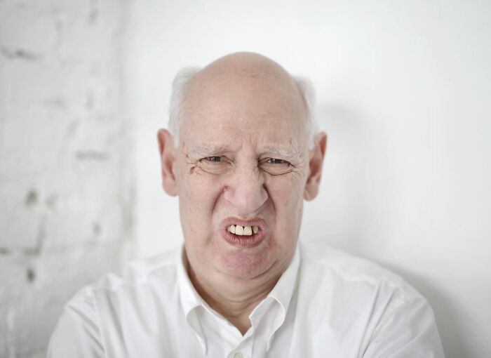 An old man making a disgusted face, depicting public horror stories and unpleasant experiences.