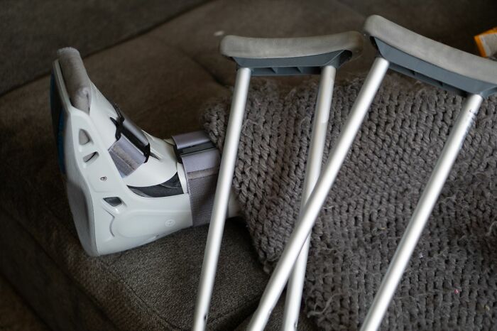 A pair of crutches and a foot in a medical boot, hinting at secrets that could do a lot of damage.