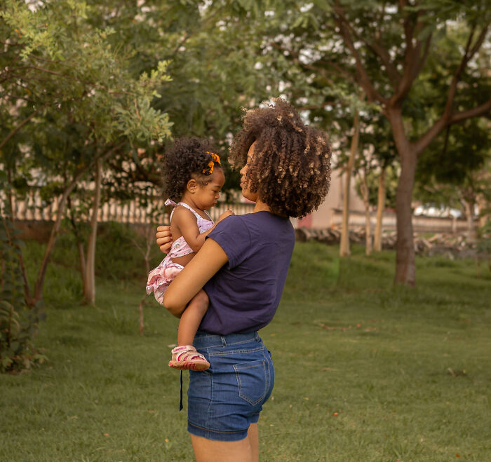 A mom holding her child in a park, illustrating the impact when child support payments stop and backfire. A mom holding her child in a park, illustrating the impact when child support payments stop and backfire.