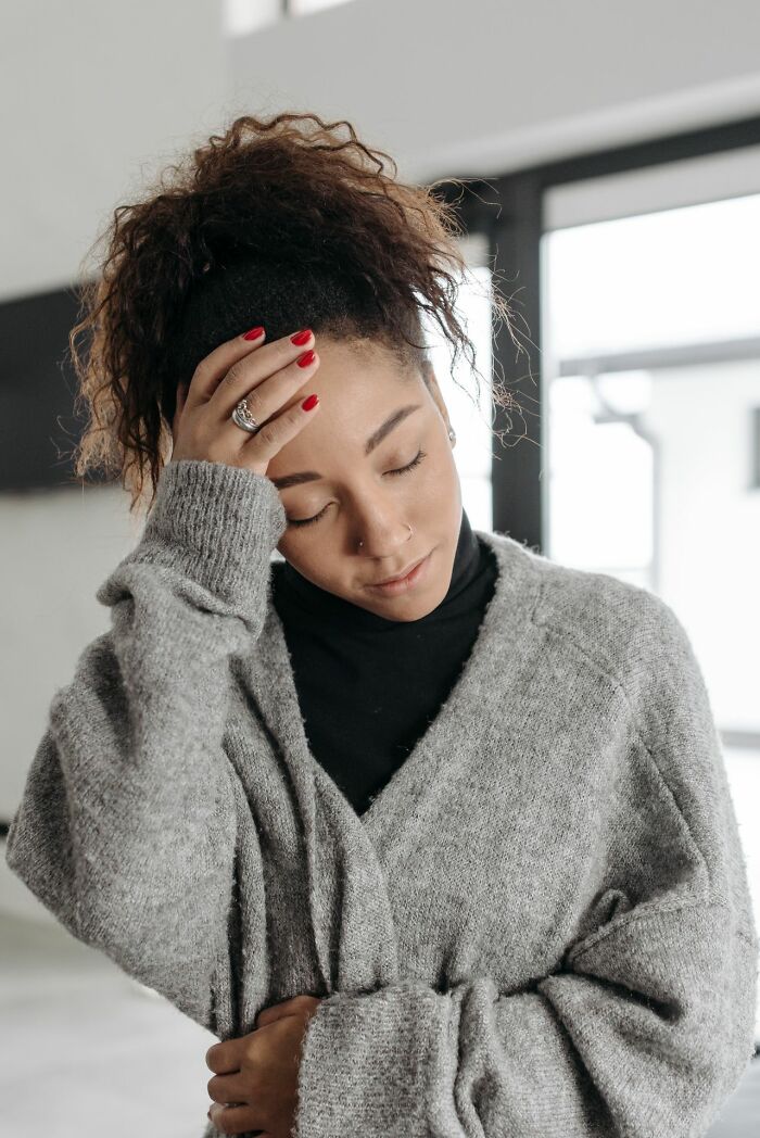 A woman with her hand on her forehead looking distressed, sharing one of the rarest things that have happened.