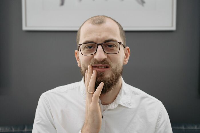Man with toothache, one of the many ridiculous HR problems adult employees create.