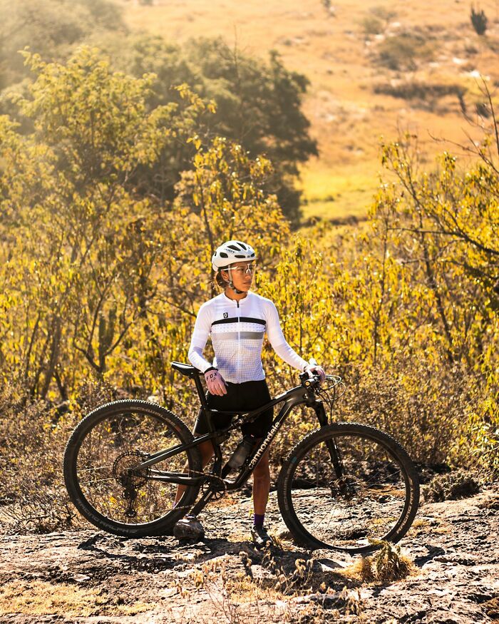A female cyclist on a trail, representing a moment to get away from deeply evil people.