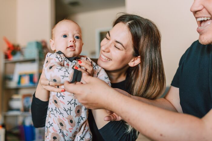 Parents happily hold their baby, celebrating an unexpected twist and turn that changed their lives profoundly.