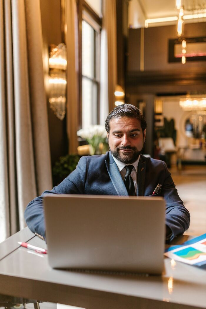 A man looking at a laptop in an office, symbolizing HR problems and adult challenges.