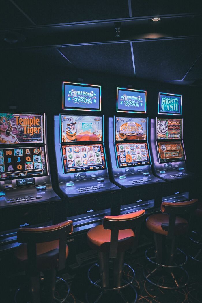 A row of slot machines in a dimly lit casino, illustrating rare things that happened to people.