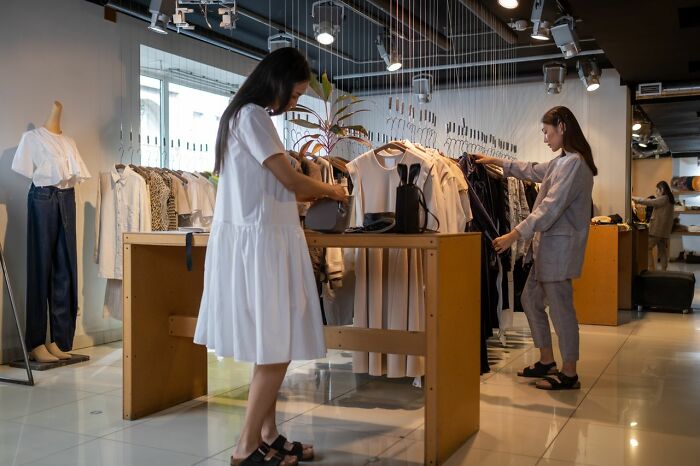 Two women shopping in a clothing store, uncovering companies secrets of the fashion industry.