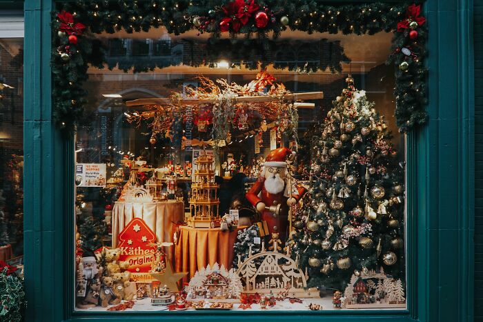 A festive shop window display with Christmas decorations, a Christmas tree, and Santa figures, unrelated to office stories.