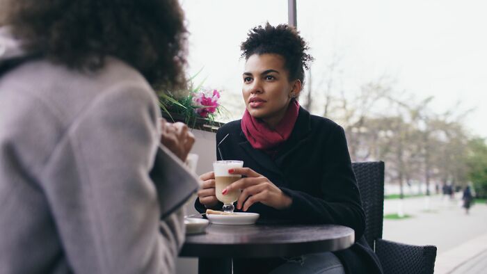 Two women having coffee, discussing psychological red flags in relationships and how to spot them.