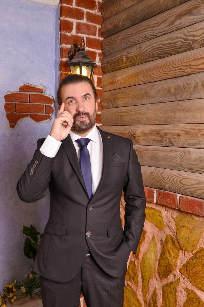 A man in a suit scratching his head, confused by American habits.