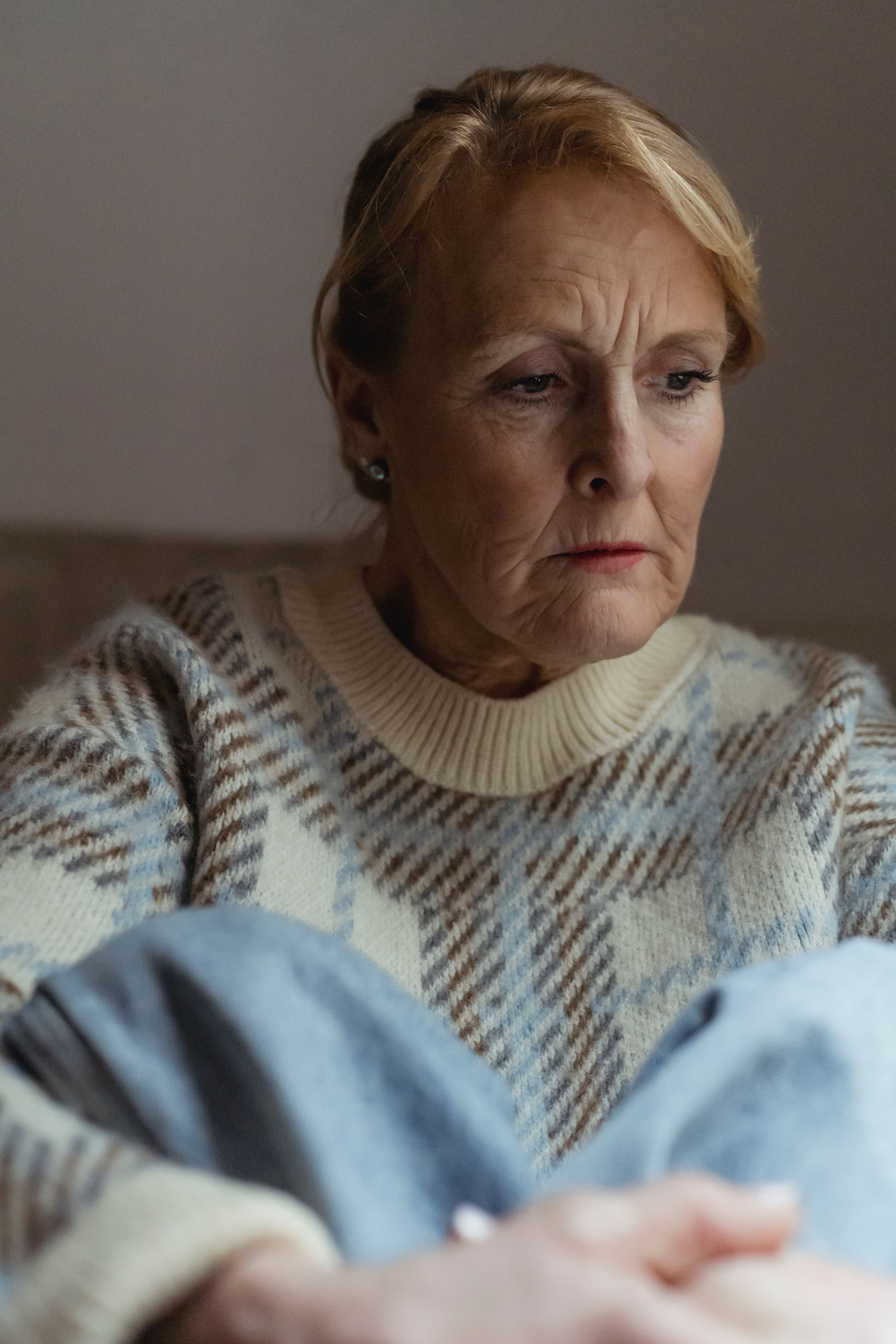 An older woman with a worried expression, reflecting on the idea of moms moving into a dream home. An older woman with a worried expression, reflecting on the idea of moms moving into a dream home.