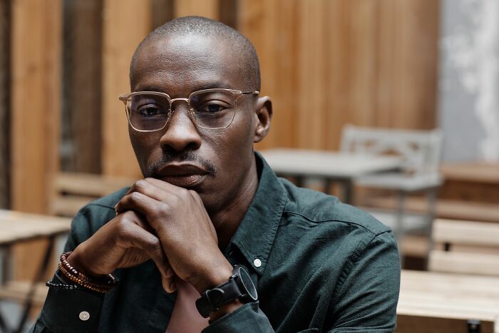A man with glasses and a serious expression, considering subtle signs someone isn't as nice as they pretend to be.