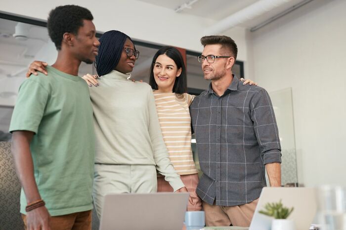 A group of diverse colleagues smiling and standing together, revealing behind the scenes secrets companies don't want you to know.