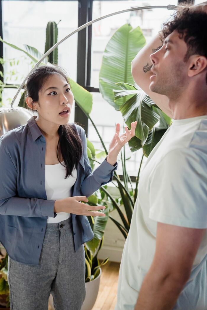 A woman arguing with a man, discussing cheating red flags in their relationship.