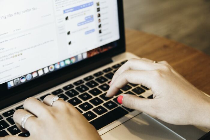 Woman typing on a laptop, revealing behind the scenes secrets companies dont want you to know from online activities.