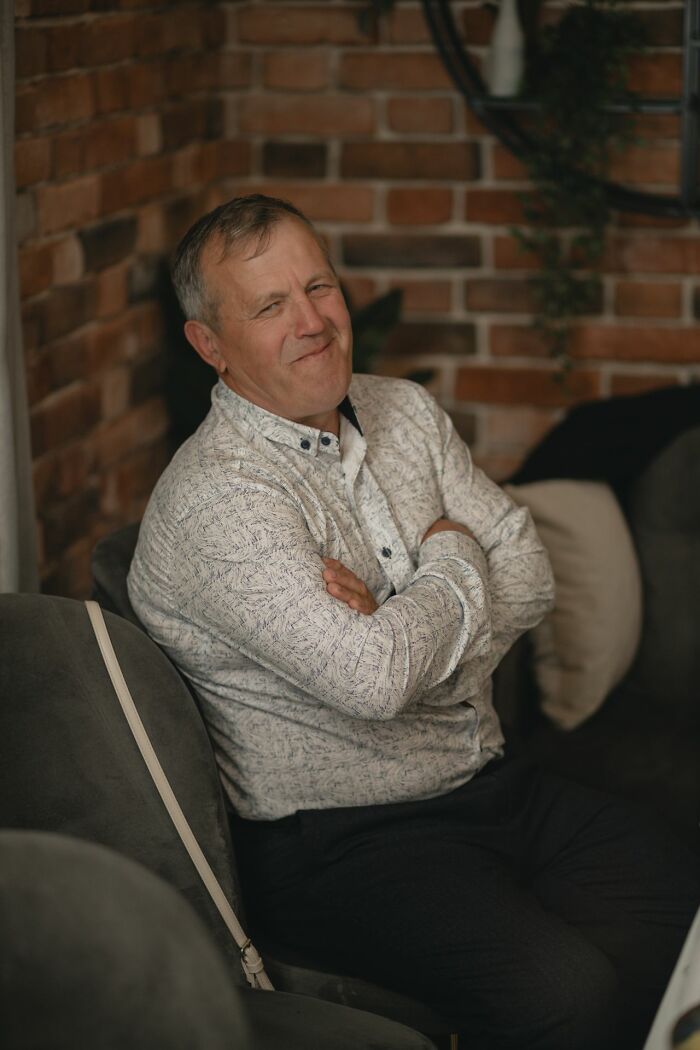 A man sitting on a couch, smirking with his arms crossed, showing phrases that crack people up.