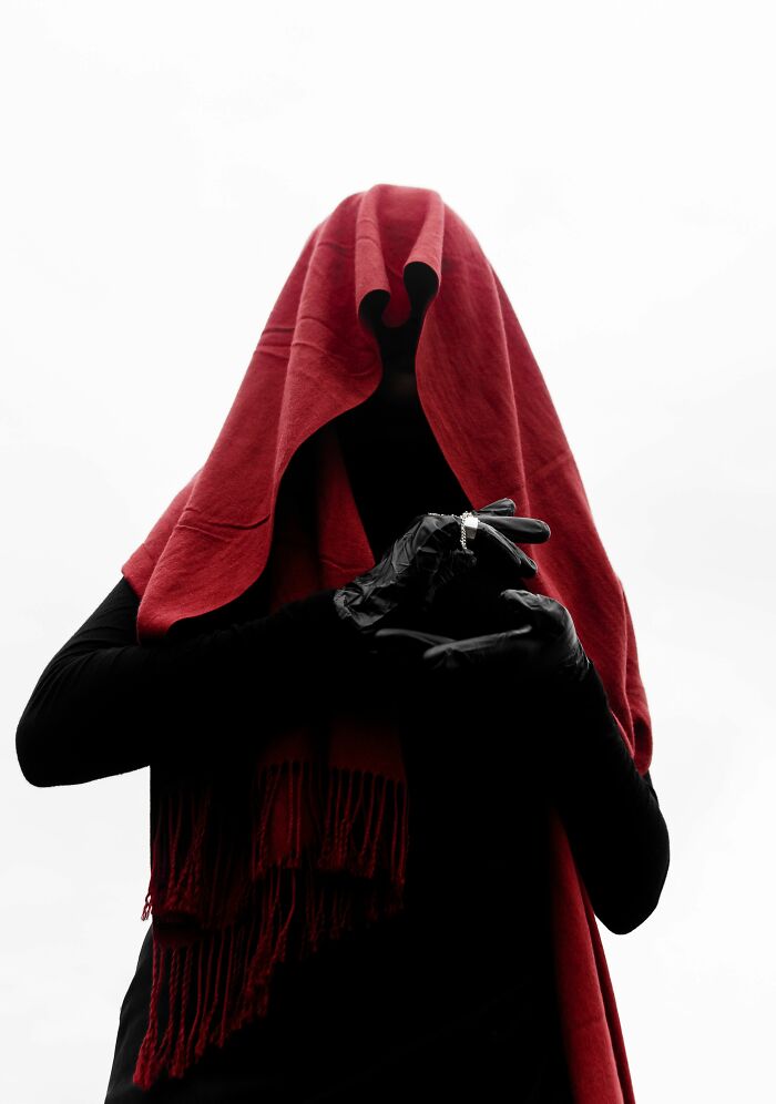 A dark, mysterious figure cloaked in a red scarf with black gloves, symbolizing an unresolved mystery or inner enigma. A dark, mysterious figure cloaked in a red scarf with black gloves, symbolizing an unresolved mystery or inner enigma.