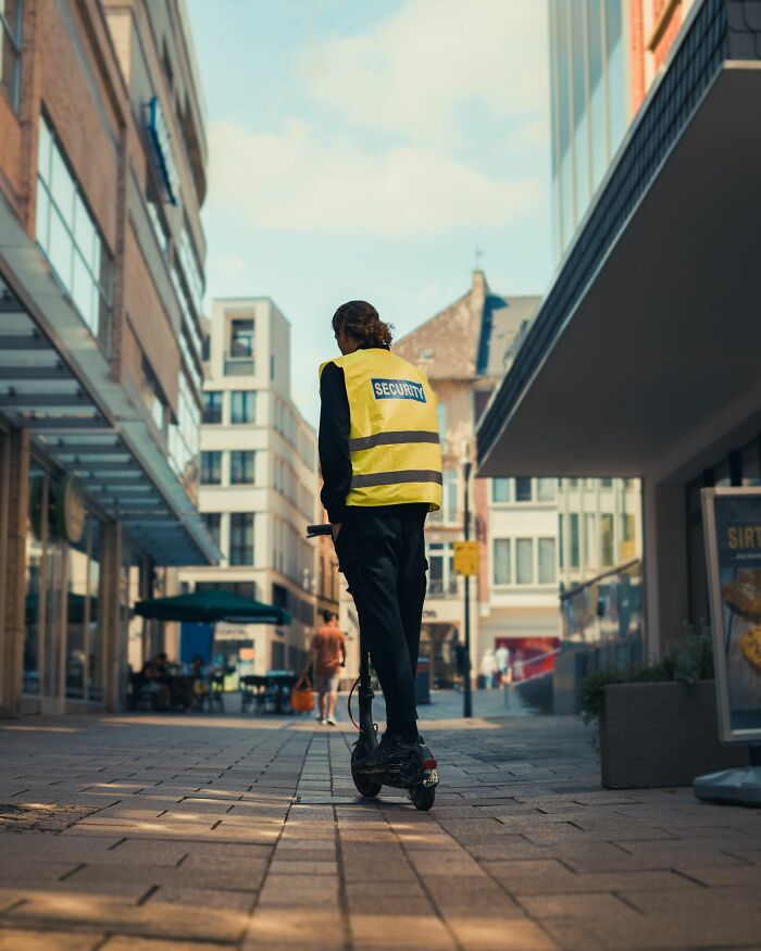 A security guard on a scooter in a city, showcasing industry secrets about jobs.