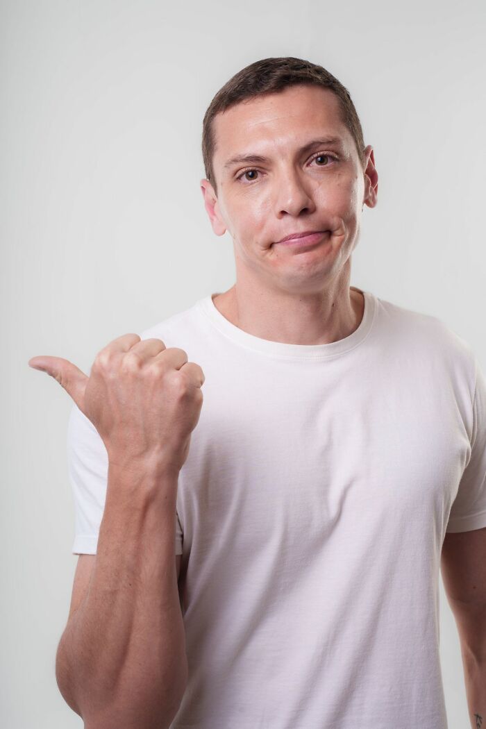 A man in a white t-shirt shrugging, with a smirk, representing a funny white phrase.