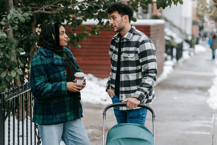 A couple with a stroller, discussing psychological red flags and parenting challenges.