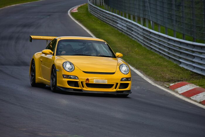 A yellow Porsche racing car on a track, suggesting kids' different experiences visiting a friend's house.