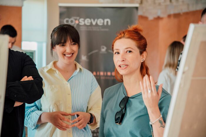 Two women smiling and chatting, possibly discussing psychological red flags in social interactions.