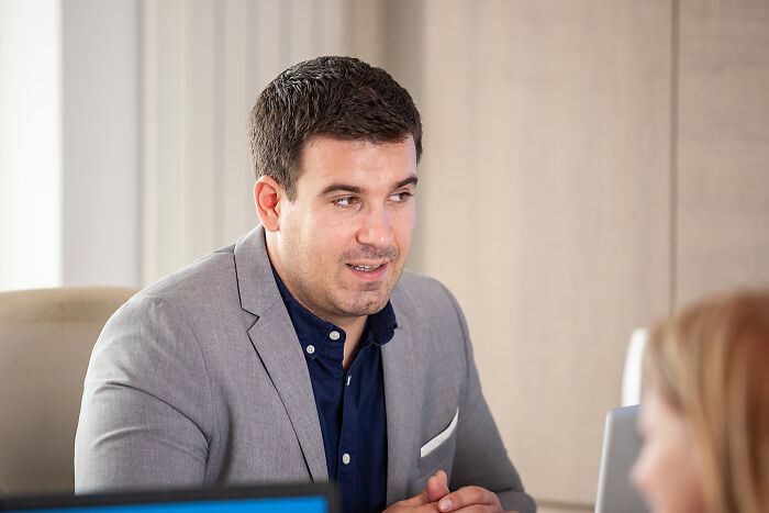A man in a blazer looking left, perhaps bored by corporate buzzwords or practices.