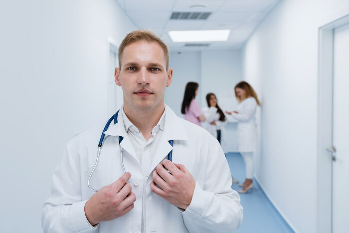 A doctor in a white coat with a stethoscope, representing jobs guys have that make women swipe left.
