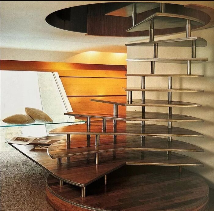 Remarkable Designs: A striking spiral staircase with individual wooden treads supported by metal rods, an iconic interior design.