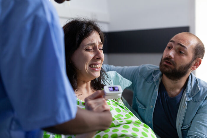 A pregnant woman crying during a difficult moment, highlighting infuriating MILs stories.