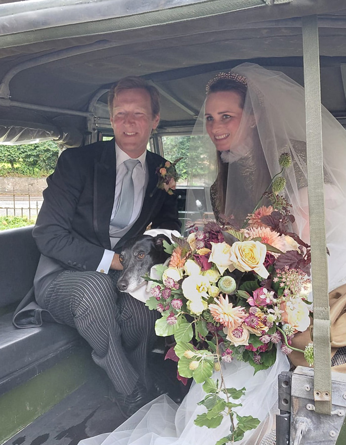 A newlywed couple with a dog in a vintage car at their fairytale wedding, celebrating true love. A newlywed couple with a dog in a vintage car at their fairytale wedding, celebrating true love.