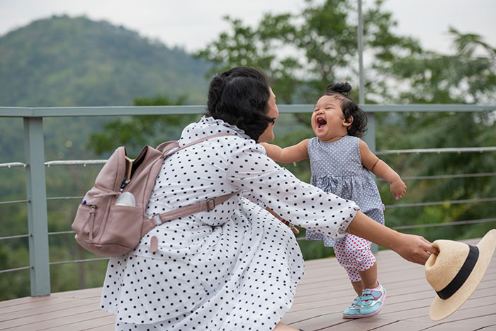 A mixed-race mom playing with her blue-eyed kid outdoors, illustrating family scandals for fun. A mixed-race mom playing with her blue-eyed kid outdoors, illustrating family scandals for fun.