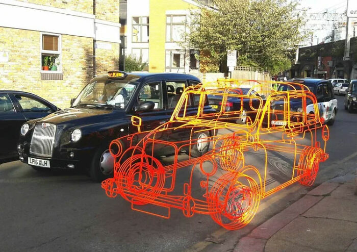 A wireframe overlay on a black taxi cab, a real photo that makes you question if it was edited.