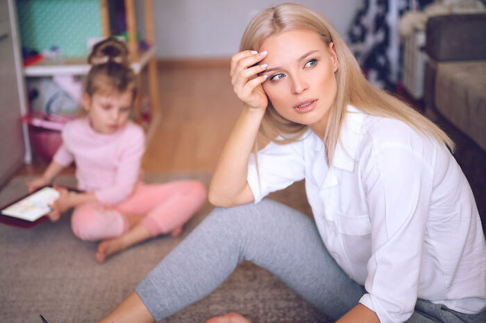 Woman with blonde hair looking distressed, a child playing in the background. Ignoring red flags because the person was hot.