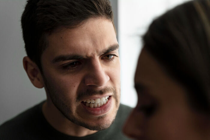 A man with great hair yelling at a person, ignoring the red flags of his sociopathic behavior.