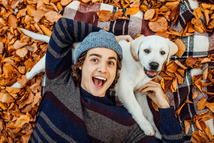 Happy man with a puppy, showing how people might ignore red flags for a hot person.