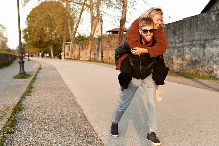 A man gives a piggyback ride to a woman, enjoying their time despite potential red flags.