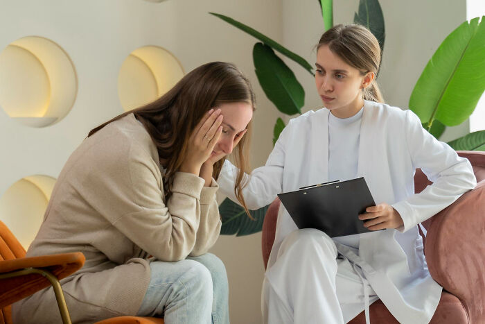 Woman comforting another woman, relating to people who ignored red flags for a hot person.