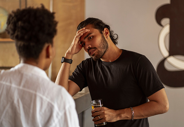 A man holds his head, looking stressed, while pursuing a friend's nanny.