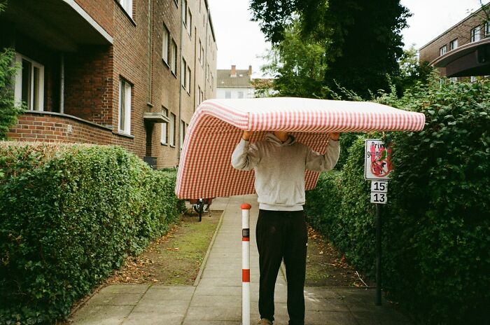A person carries a mattress on a sidewalk, symbolizing the adjustments and culture shocks international partners face.