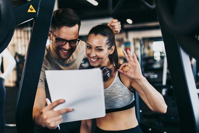 A personal trainer with a client at the gym, revealing how people are getting scammed in the fitness industry.