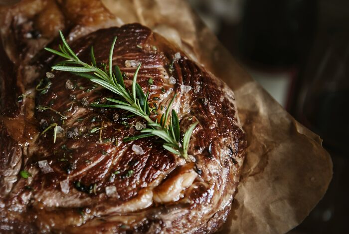 A perfectly cooked steak with rosemary and coarse salt, hinting at ways people are getting scammed.