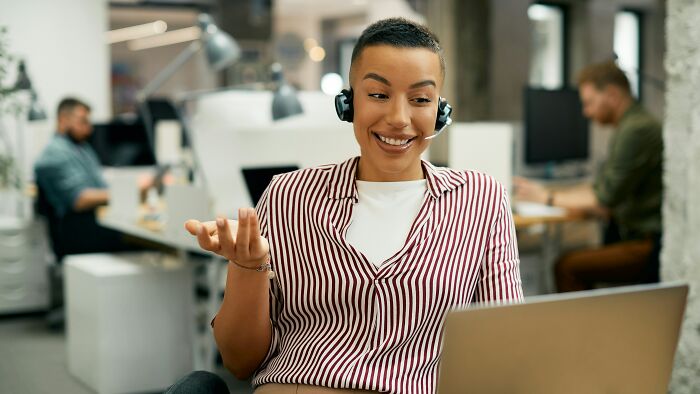 Smiling call center worker with a headset, symbolizing industries where people are getting scammed through deceptive customer service.