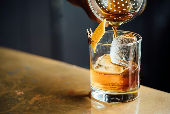 A bartender pouring a drink, representing ways people are getting scammed in the hospitality industry.